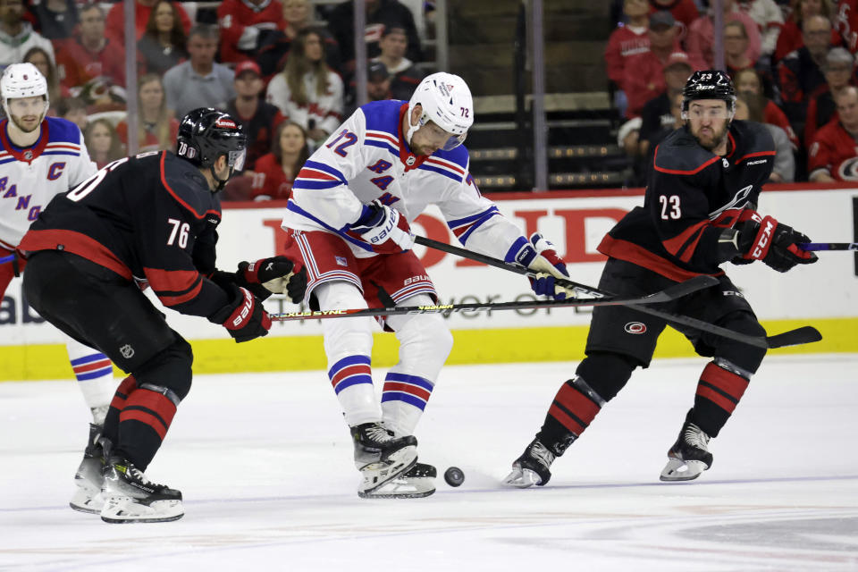 New York Rangers center Filip Chytil (72) works between Carolina Hurricanes defenseman Brady Skjei (76) and right wing Stefan Noesen (23) for the puck during the first period in Game 3 of an NHL hockey Stanley Cup second-round playoff series Thursday, May 9, 2024, in Raleigh, N.C. (AP Photo/Chris Seward)