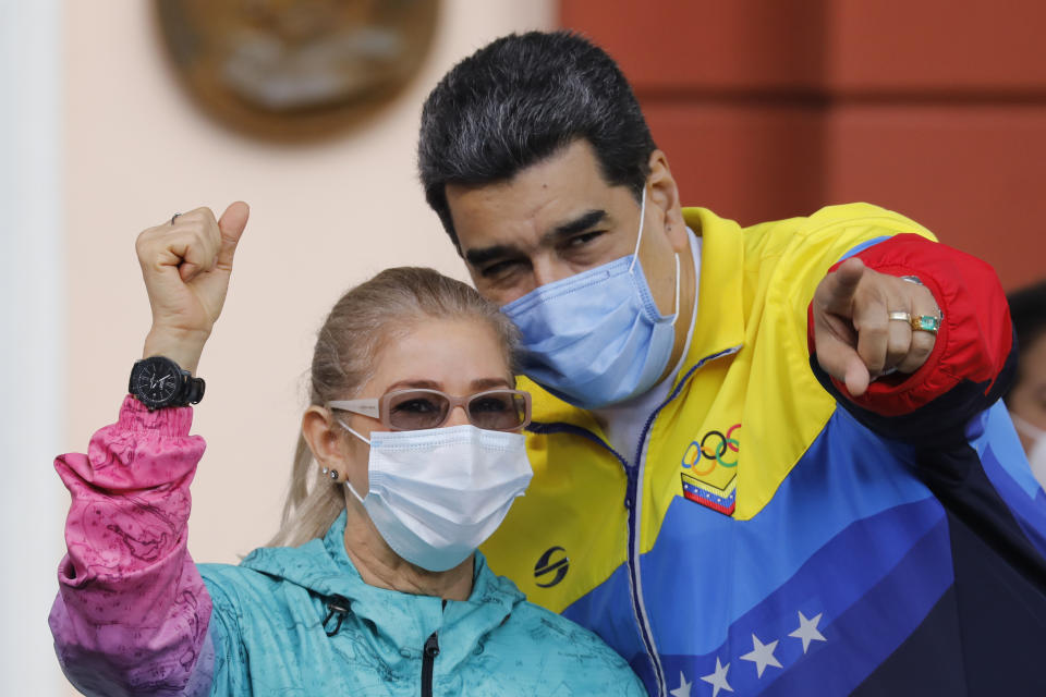 Venezuelan President Nicolas Maduro points to supporters during an event with his wife Cilia Flores marking Youth Day at Miraflores presidential palace in Caracas, Venezuela, Friday, Feb. 12, 2021, amid the COVID-19 pandemic. The annual holiday commemorates young people who accompanied heroes in the battle for Venezuela's independence. (AP Photo/Ariana Cubillos)