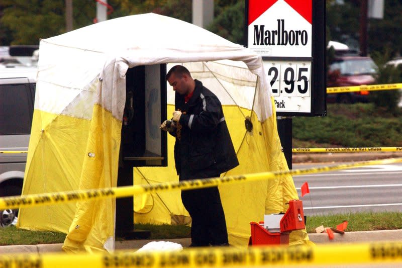 A police officer collects evidence at a gas station where a suspect was picked up earlier in connection with the sniper attacks in the Washington area, in Henrico County, Va., October 21, 2002. On December 18, 2003, teenager Lee Malvo was convicted of murder in Washington-area sniper attacks that killed 10 people. He was sentenced to life in prison.File Photo by Chris Cordedr/UPI