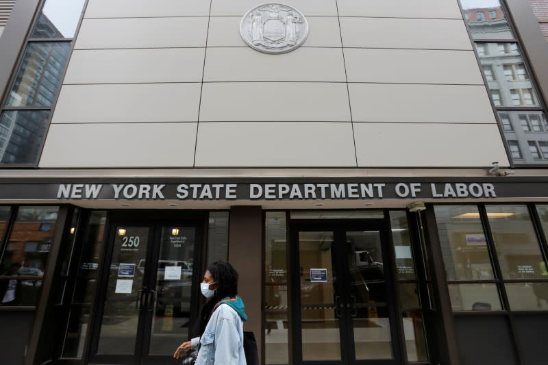 FILE PHOTO: A person walks by the entrance of the New York State Department of Labor offices, which closed to the public due to the coronavirus disease (COVID-19) outbreak in the Brooklyn borough of New York City