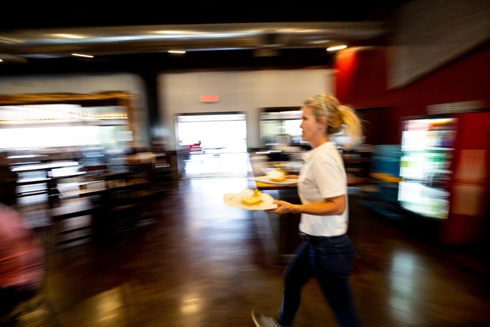 Katherine Parker delivers food at her restaurant in Alpine, Texas. A labor shortage in the town has impacted businesses in the hospitality industry.