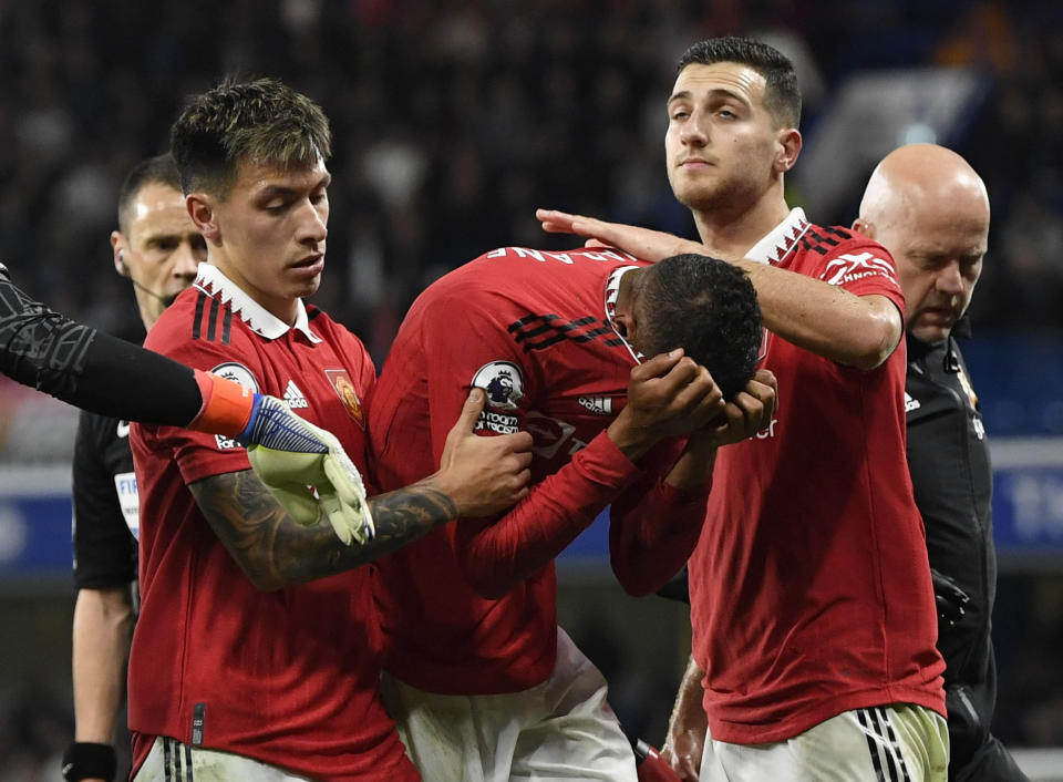 Manchester United's Raphael Varane (centre) is consoled by teammates as he walks off the pitch after suffering an injury in the English Premier League match against Chelsea.