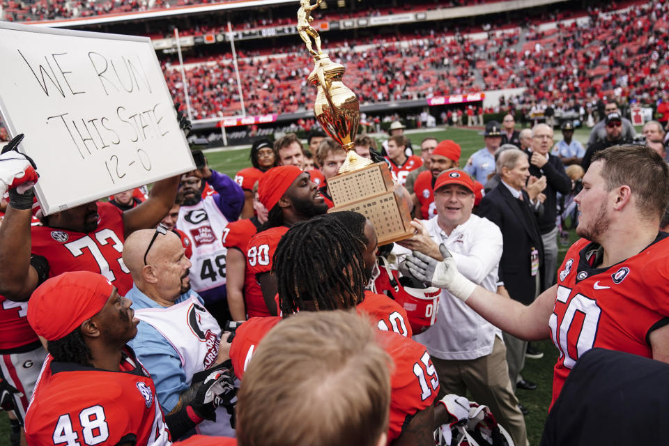 Georgia head coach Kirby Smart and his player hoist the Governor's Cup after defeating Georgia Tech in an NCAA college football game Saturday, Nov. 26, 2022 in Athens, Ga. (AP Photo/John Bazemore)