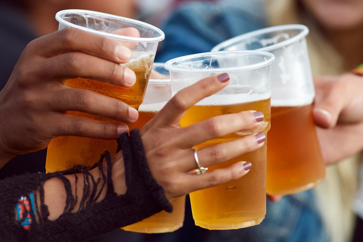 A group of people toasting at an outdoor beer festival