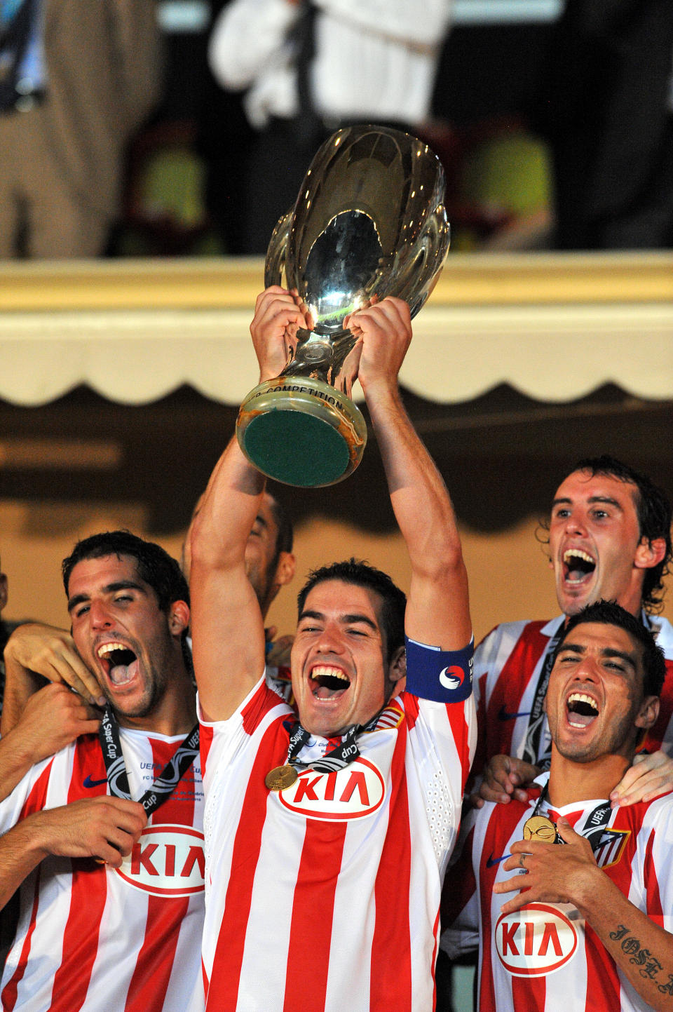 Atletico Madrid's Antonio Lopez (holding cup) celebrates Super Cup victory with Raul Garcia (left) and Reyes (right) (Photo by Neal Simpson - EMPICS/PA Images via Getty Images)
