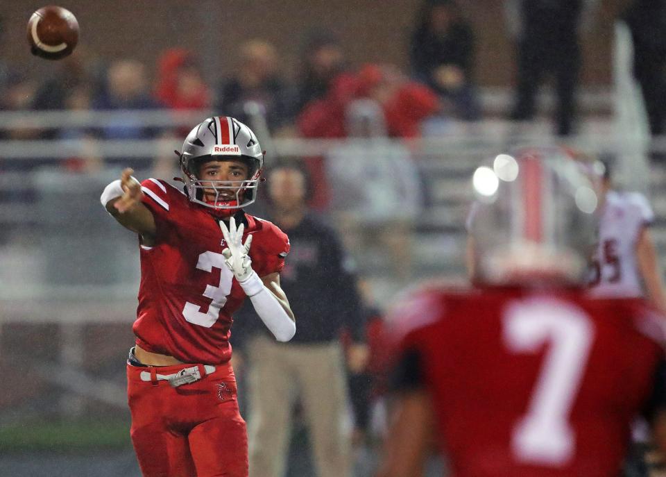 East quarterback Darshaun Sales throws a pass to running back Ziaire Stevens during the second half of a Division III playoff football game against Canfield on Friday in Akron.