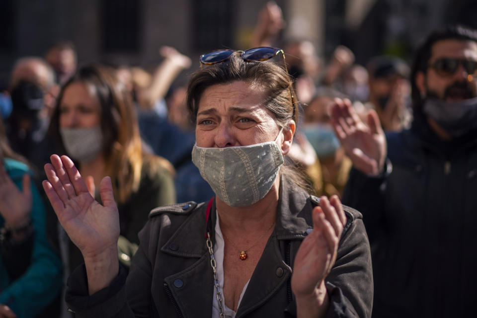 A woman cries during a protest organised by restaurant and bar owners in Barcelona, Spain, Wednesday Oct. 14, 2020. Authorities in northeastern Spain ordered shut all bars and restaurants for two weeks. Restaurant and bar owners protested the measure in Catalonia, saying that they already suffered a huge hit when closed in the nationwide lockdown in the spring. (AP Photo/Emilio Morenatti)