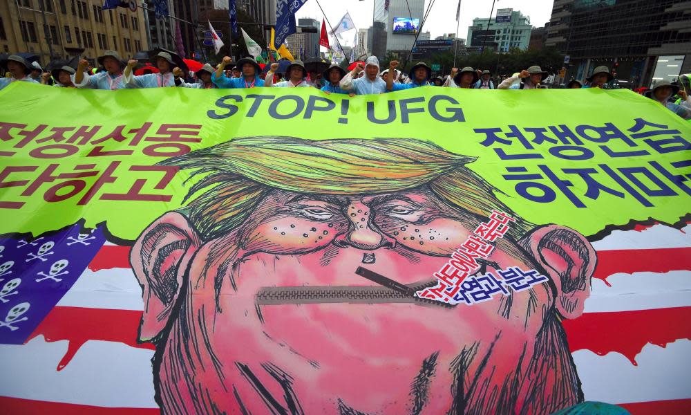 Protesters in Seoul, South Korea, carry a banner showing a caricature of Donald Trump during an anti-US rally demanding peace in the Korean peninsula on 15 August 2017