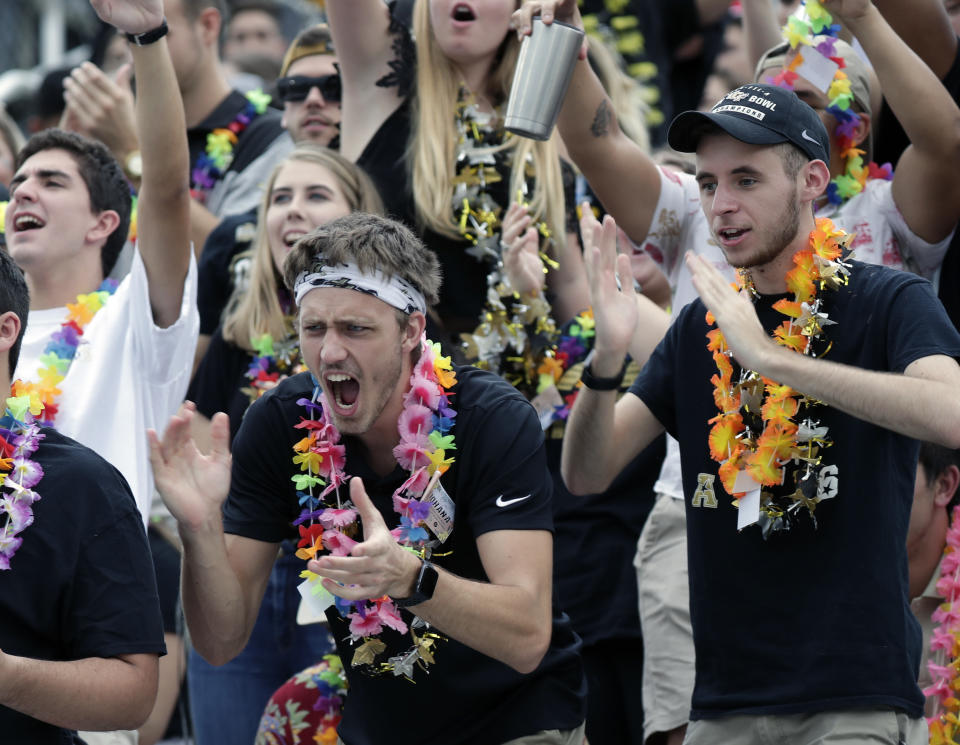 Central Florida students wearing Hawaiian leis cheer before start of the American Athletic Conference championship NCAA college football game between Central Florida and Memphis, Saturday, Dec. 1, 2018, in Orlando, Fla. Over 40,000 leis were distributed to fans before the game to show support for injured quarterback McKenzie Milton who is from Hawaii. (AP Photo/John Raoux)