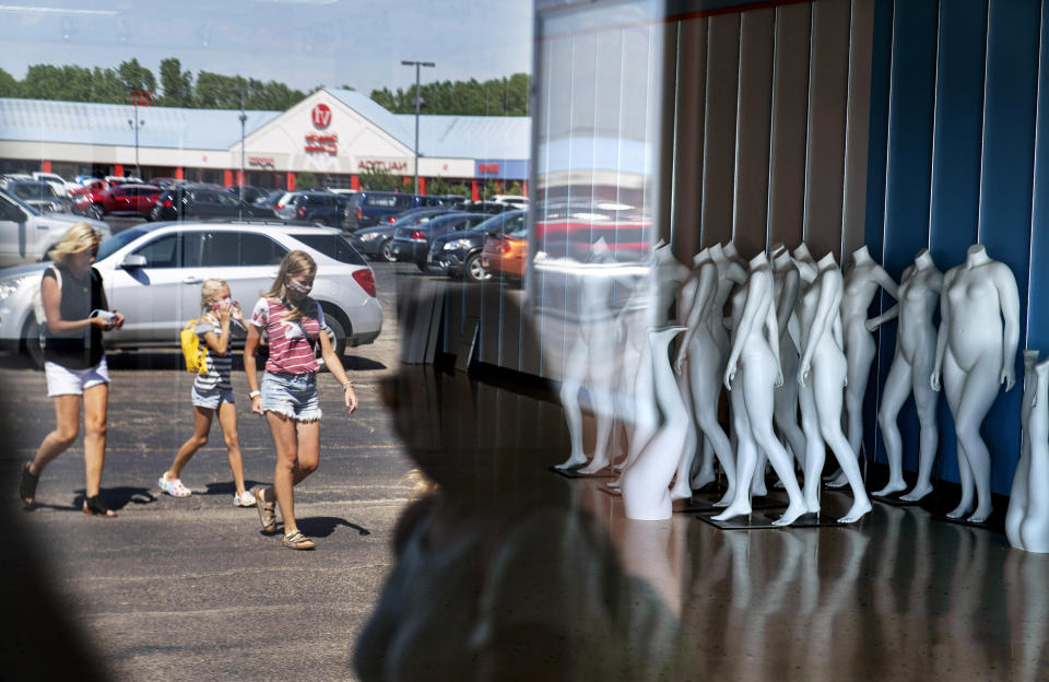 Mannequins stand in an empty store as shoppers visit outlet shops in Oshkosh, Wis., part of the greater Appleton area, Aug. 20, 2020. Storefronts after the pandemic have been emptied at the Oshkosh Outlets, including the nearby Brooks Brothers, the haberdashery for generations of presidents, that filed for bankruptcy this year. (AP Photo/David Goldman)