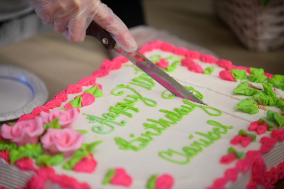 Attendees make cuts to birthday cake during Herndon's upcoming 104th birthday celebration inside Brookdale Jackson Oaks in Jackson, Tenn., on Wednesday, Jan. 3, 2024.