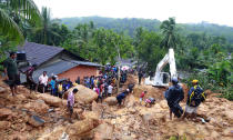 <p>Sri Lankans watch military rescue efforts at the site of a landslide at Bellana village in Kalutara district, Sri Lanka, May 26, 2017. Mudslides and floods triggered by heavy rains in Sri Lanka killed dozens and left many more missing on Friday. (Photo: Eranga Jayawardena/AP) </p>