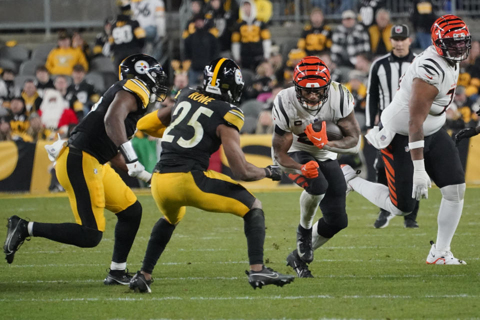 Cincinnati Bengals running back Joe Mixon, third from left, carries the ball as Pittsburgh Steelers safety Eric Rowe (25) moves in during the second half of an NFL football game Saturday, Dec. 23, 2023, in Pittsburgh. (AP Photo/Gene J. Puskar)