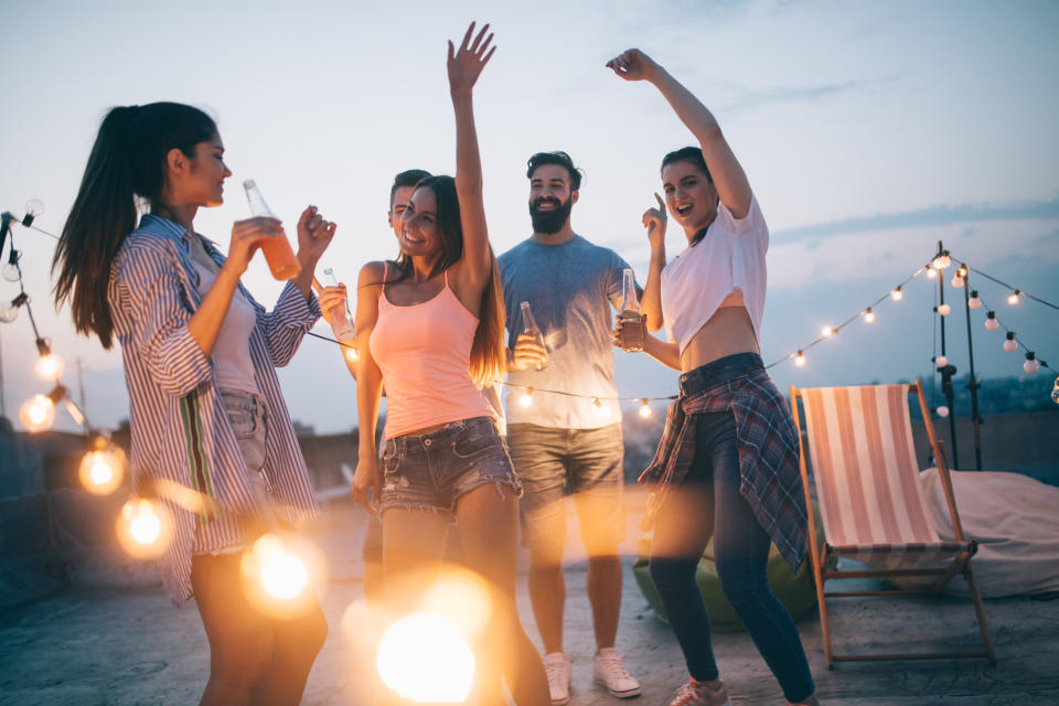 Happy friends having party on top of the roof . Fun, summer, city lifestyle and friendship concept