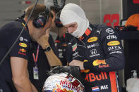 Red Bull driver Max Verstappen of the Netherlands chats with his crew member during the first practice session at the Marina Bay City Circuit ahead of the Singapore Formula One Grand Prix in Singapore, Friday, Sept. 20, 2019. (AP Photo/Vincent Thian)