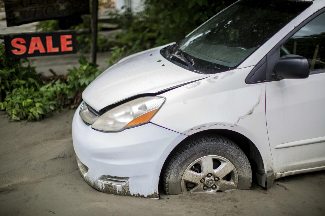 A vehicle is buried in silt.