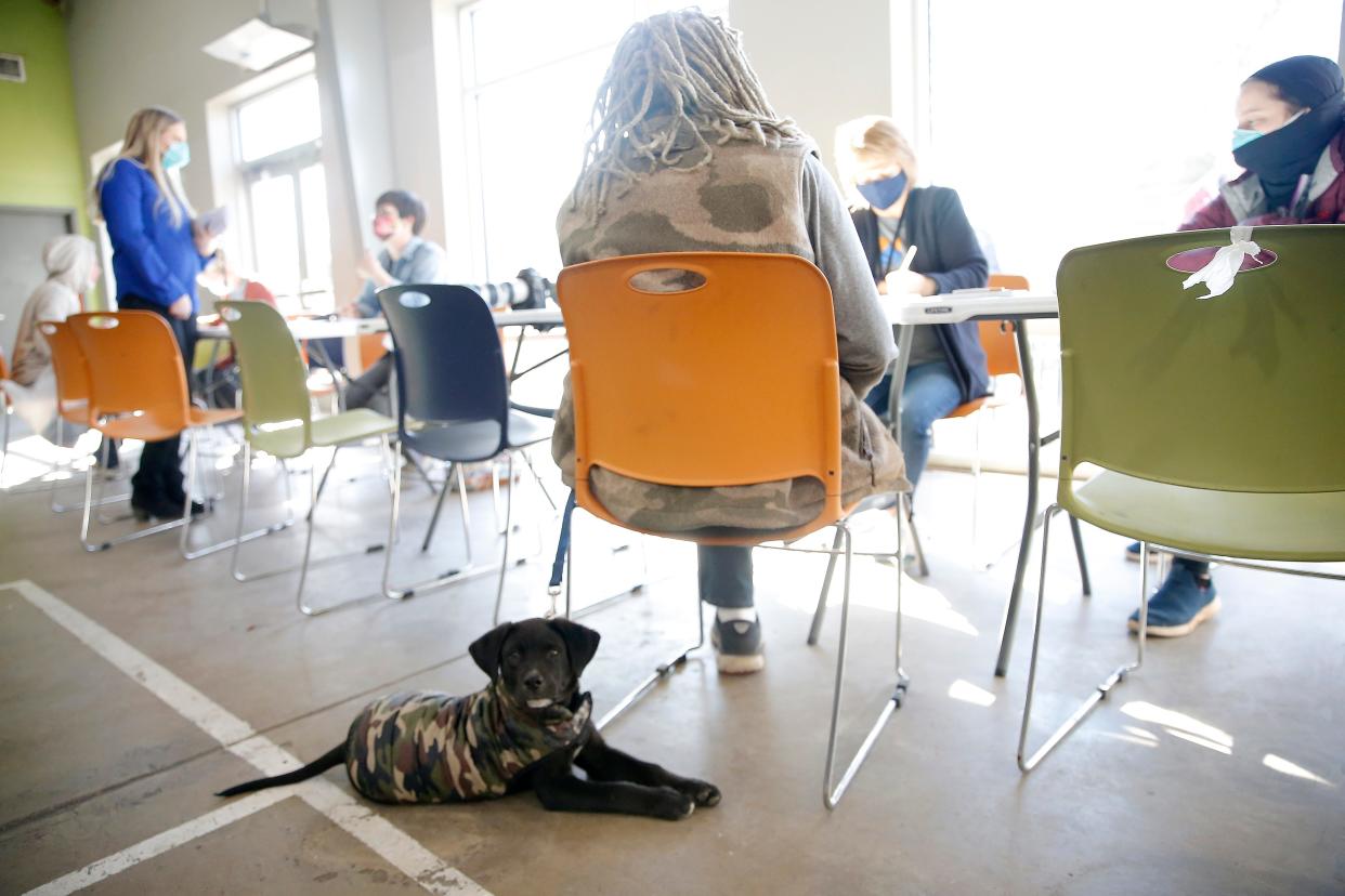 In this March 3 photo, Donna Pursifull asks Juanita Dozier questions as her dog, One Toe, sits next to her during the point in time count of people experiencing homelessness in Oklahoma City at the The Homeless Alliance day shelter.
