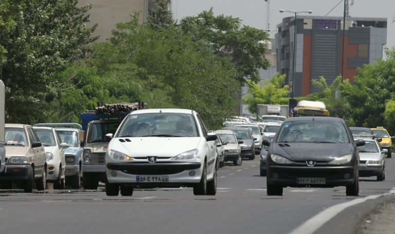 Iranians drive locally-manufactured Peugeot 206 cars in the streets of Tehran on July 24, 2012