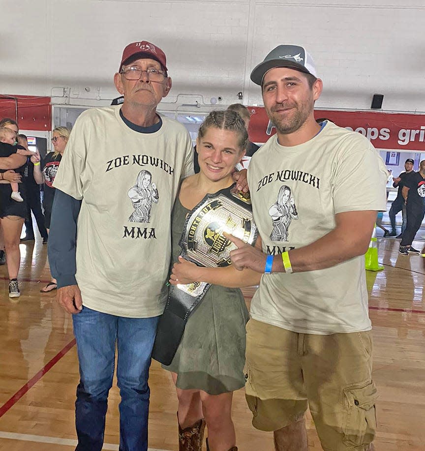 Coldwater's Zoe Nowicki poses with coaches from the Branch County MYWA program after winning the Lights Out Championship Flyweight title this past Saturday.