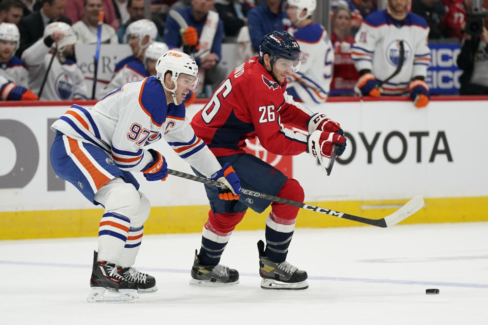 Edmonton Oilers center Connor McDavid, left, and Washington Capitals center Nic Dowd chase for possession of the puck in the first period of an NHL hockey game, Monday, Nov. 7, 2022, in Washington. (AP Photo/Patrick Semansky)