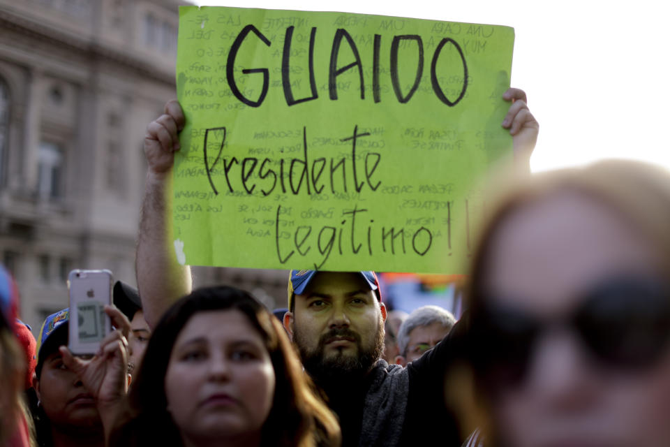 A Venezuelan anti-government protester holds a sign that reads in Spanish "Guaido legitimate President!" during a demonstration in Buenos Aires, Argentina, Wednesday, Jan. 23, 2019. Hundreds of people, mostly Venezuelan migrants, held a rally against Venezuelan President Nicolas Maduro and in favor of Juan Guaido, head of Venezuela's opposition-run congress who today proclaimed himself president of the South American nation. (AP Photo/Natacha Pisarenko)