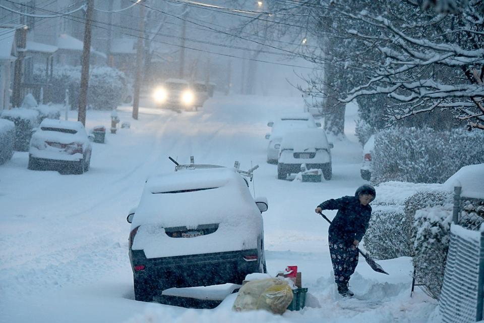 A woman shovels snow from her walkway on Tatman Street in Worcester early Friday, Jan. 7, 2022.