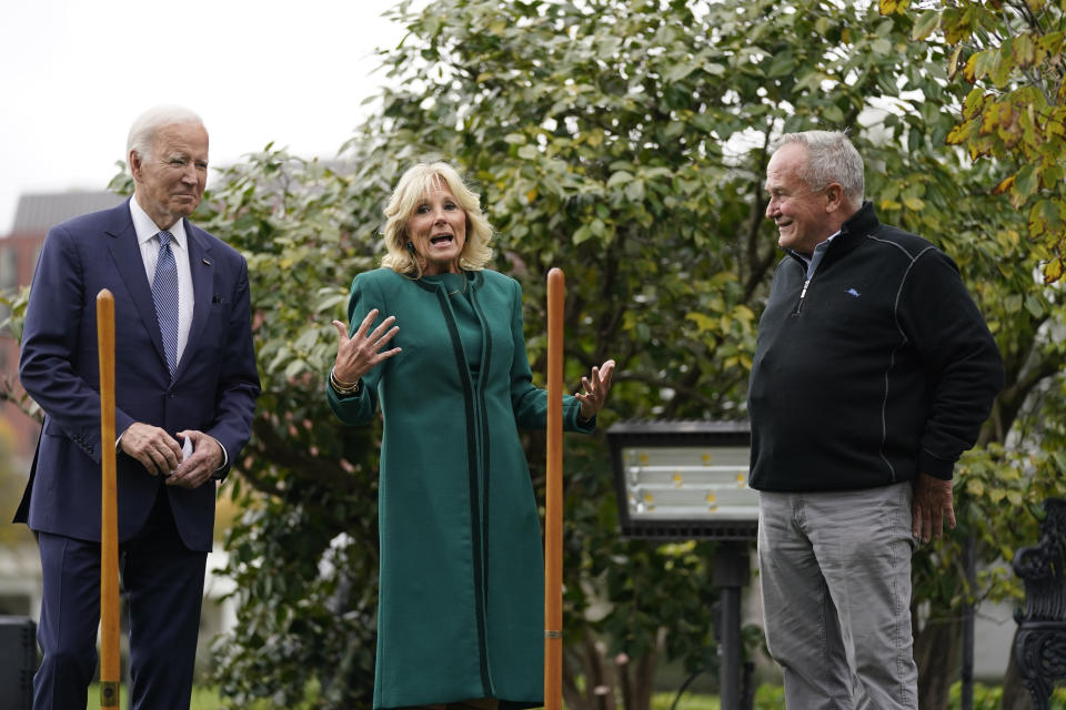 President Joe Biden, left, and Dale Haney, the chief White House groundskeeper, right, listen as first lady Jill Biden speaks during a tree planting ceremony on the South Lawn of the White House, Monday, Oct. 24, 2022, in Washington. The Bidens recognized Haney who as of this month has tended the lawns and gardens of the White House for 50 years. (AP Photo/Evan Vucci)