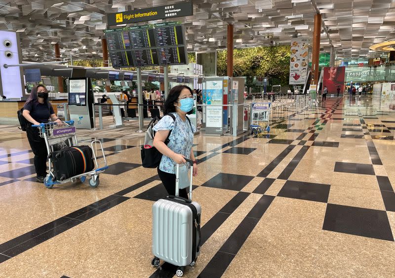 Chu Wenhong walks at airport before a journey home to China, in Singapore