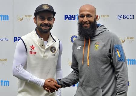 India's captain Virat Kohli (L) shakes hands with the South African captain Hashim Amla after their second cricket test match was called off due to rain and wet outfield in Bengaluru, India, November 18, 2015. REUTERS/Abhishek N. Chinnappa