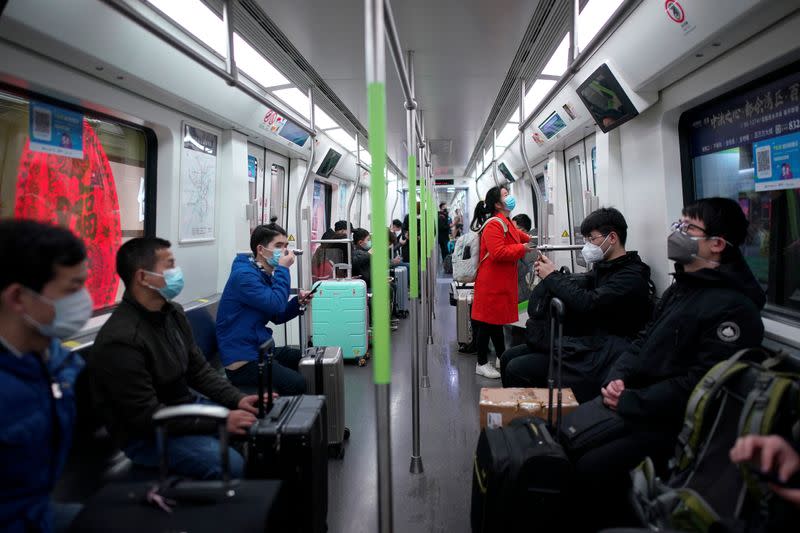 Passengers wearing face masks ride a subway train on the first day of city's subway services resumed following the novel coronavirus disease (COVID-19) outbreak in Wuhan