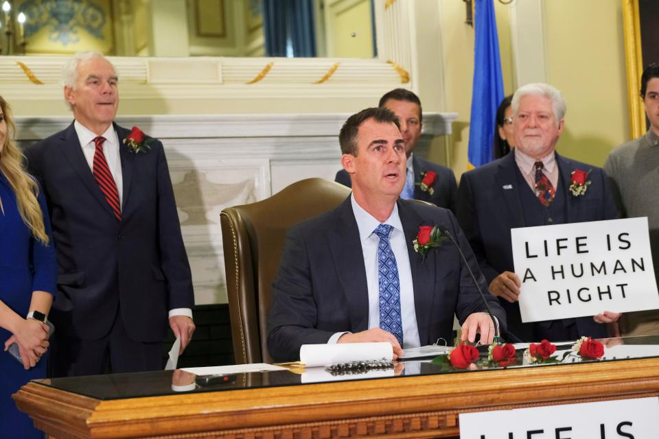 Gov. Kevin Stitt signs Senate Bill 612 on Tuesday, April 12, 2022, in the Blue Room at the Capitol.