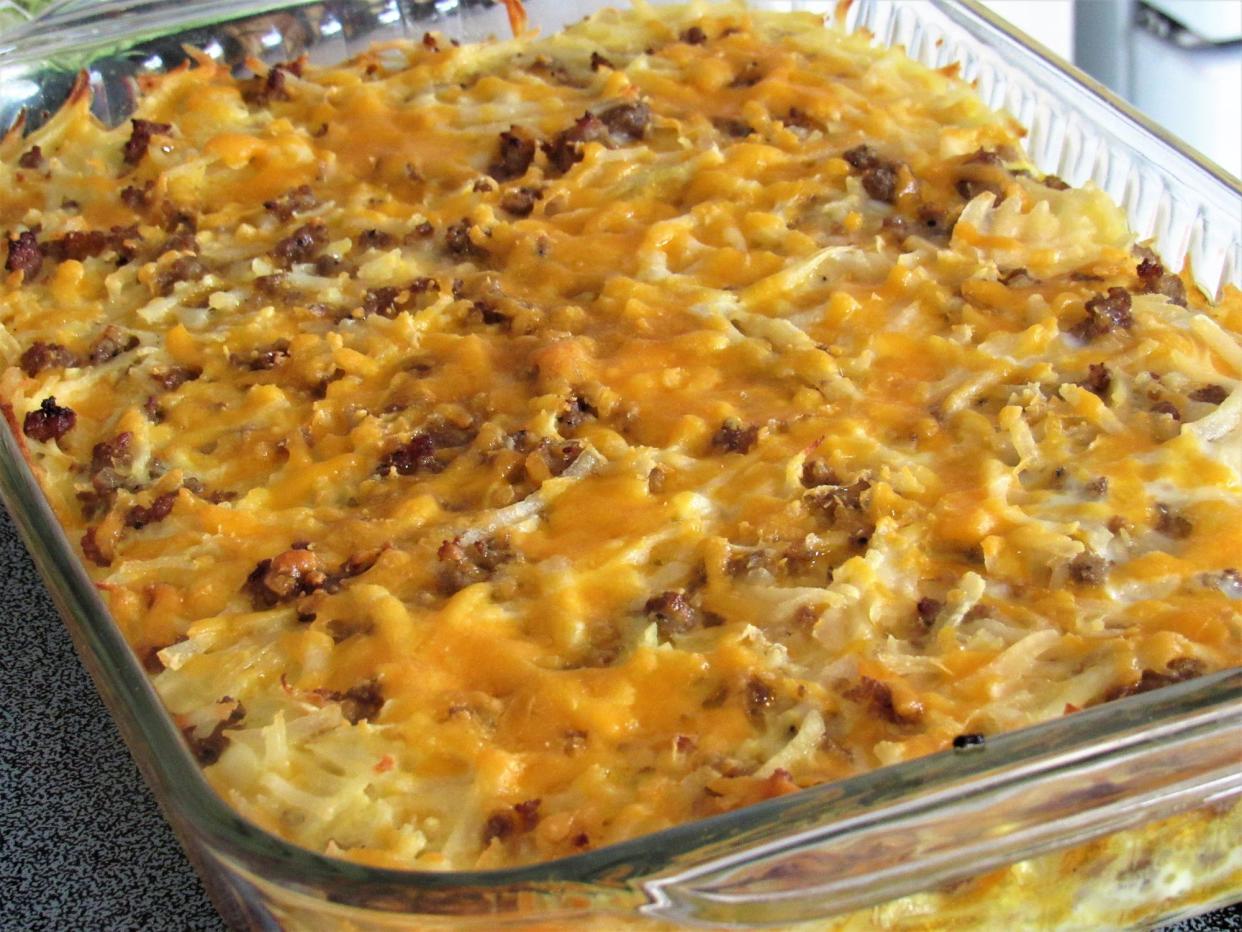 Breakfast casserole in glass baking dish, featuring sausage, cheese, egg and hash browns.