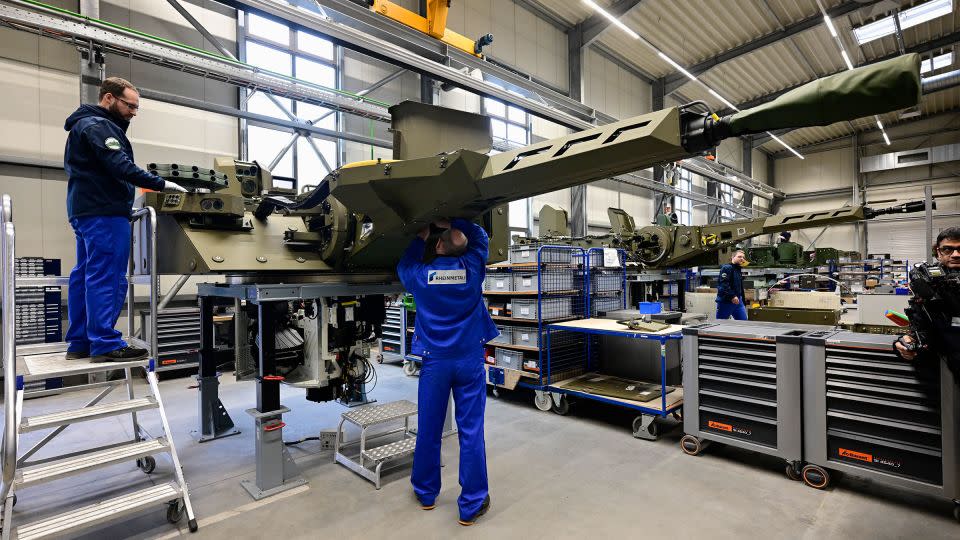 Employees work at a production line as German Chancellor Olaf Scholz and Defence Minister Boris Pistorius attend the groundbreaking ceremony for a new munitions factory of German defense contractor Rheinmetall on February 12 in Unterluess, Germany. - Fabian Bimmer/Pool/Getty Images