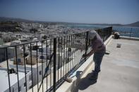 Workers paint the terrace of an all-day cafe bar restaurant in Chora, on the Aegean island of Naxos, Greece, Tuesday, May 11, 2021. (AP Photo/Thanassis Stavrakis)