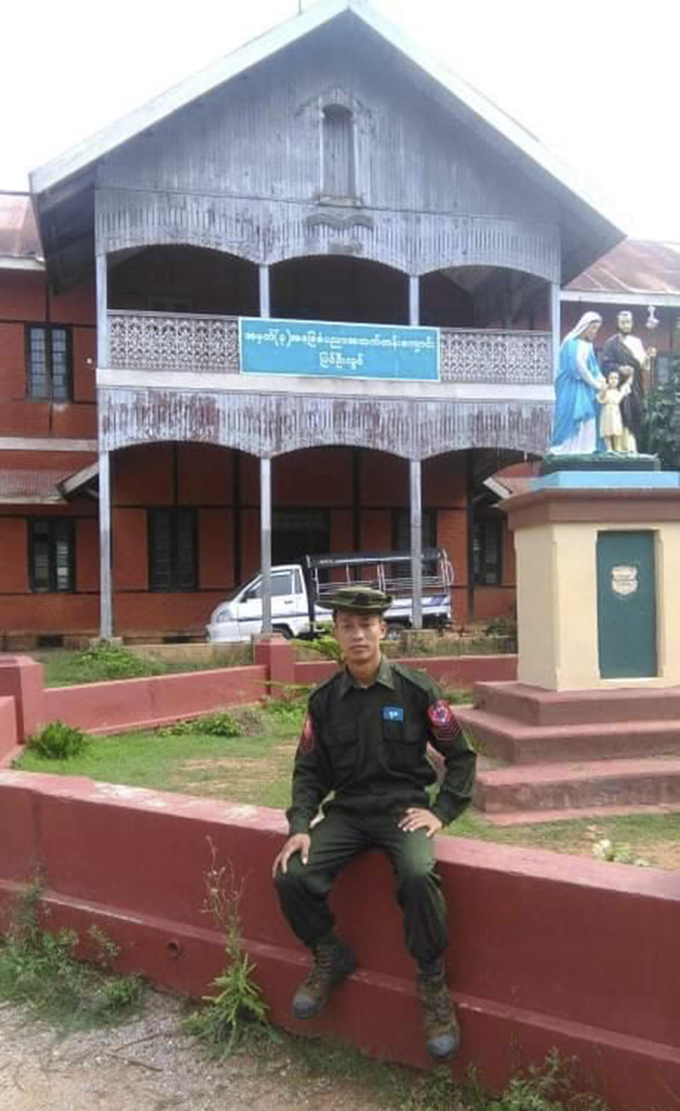 This undated photo provided by Hin Lian Piang in 2021 shows him in front of the No. 3 Basic Education High School building in Pyin Oo Lwin, Myanmar. Hin Lian Piang, who served as a clerk to the North-Western Regional Deputy Commander before defecting in October, witnessed soldiers torture two prisoners to death at a mountaintop interrogation center inside an army base in Chin state in May 2021. The soldiers beat the two men, hit them with their guns, and kicked them, he says. After the men were put into jail, both died. (Courtesy Hin Lian Piang via AP)