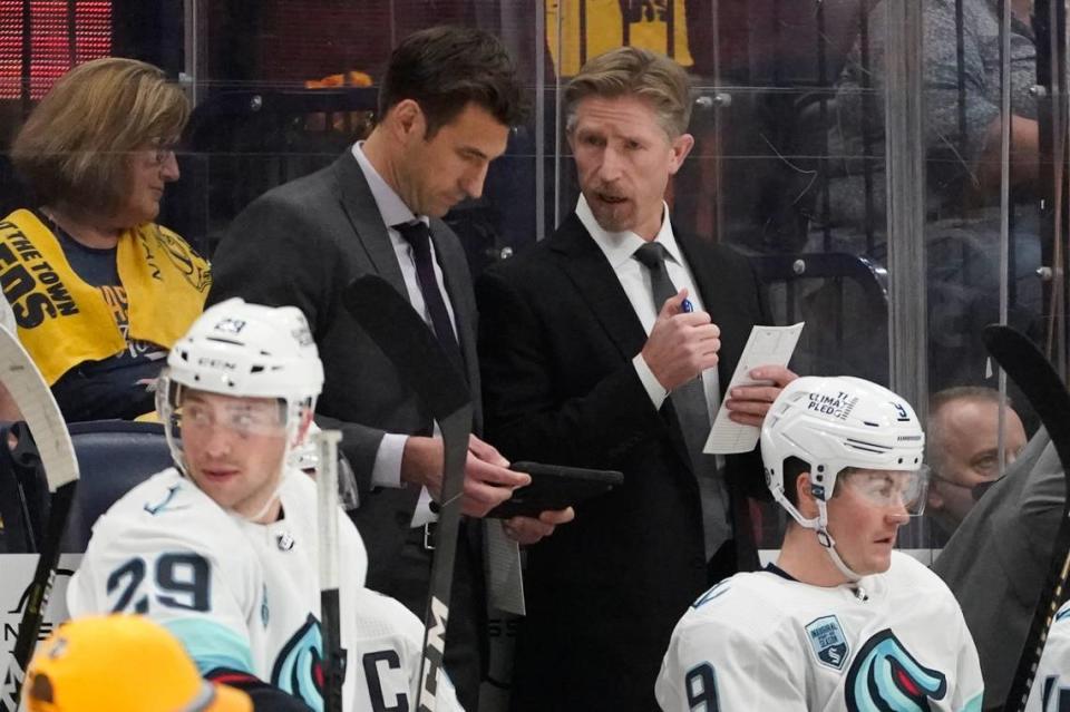 Seattle Kraken head coach Dave Hakstol, center right, talks with assistant coach Jay Leach in the second period of an NHL hockey game against the Nashville Predators Thursday, Oct. 14, 2021, in Nashville, Tenn. (AP Photo/Mark Humphrey)