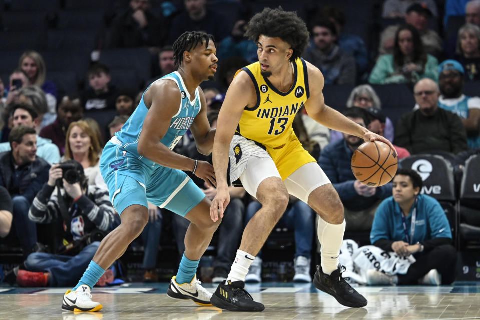 Charlotte Hornets guard Dennis Smith Jr. (8) defends against Indiana Pacers forward Jordan Nwora (13) during the first half of an NBA basketball game, Monday, March 20, 2023, in Charlotte, N.C. (AP Photo/Matt Kelley)