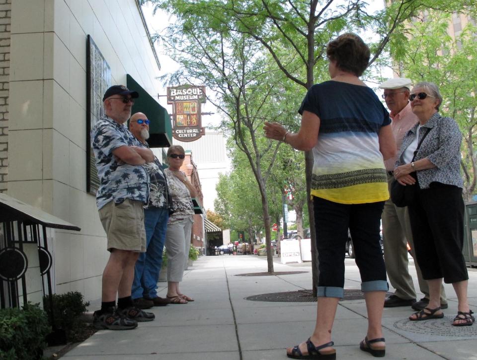 This Aug. 7, 2013 photo shows a Basque Museum and Cultural Center guide, foreground, giving a tour outside the museum in Boise, Idaho. The museum is one of several stops on the city’s downtown Basque Block to learn more about the history and influence Basques have had on the city and surrounding area. (AP Photo/Todd Dvorak)