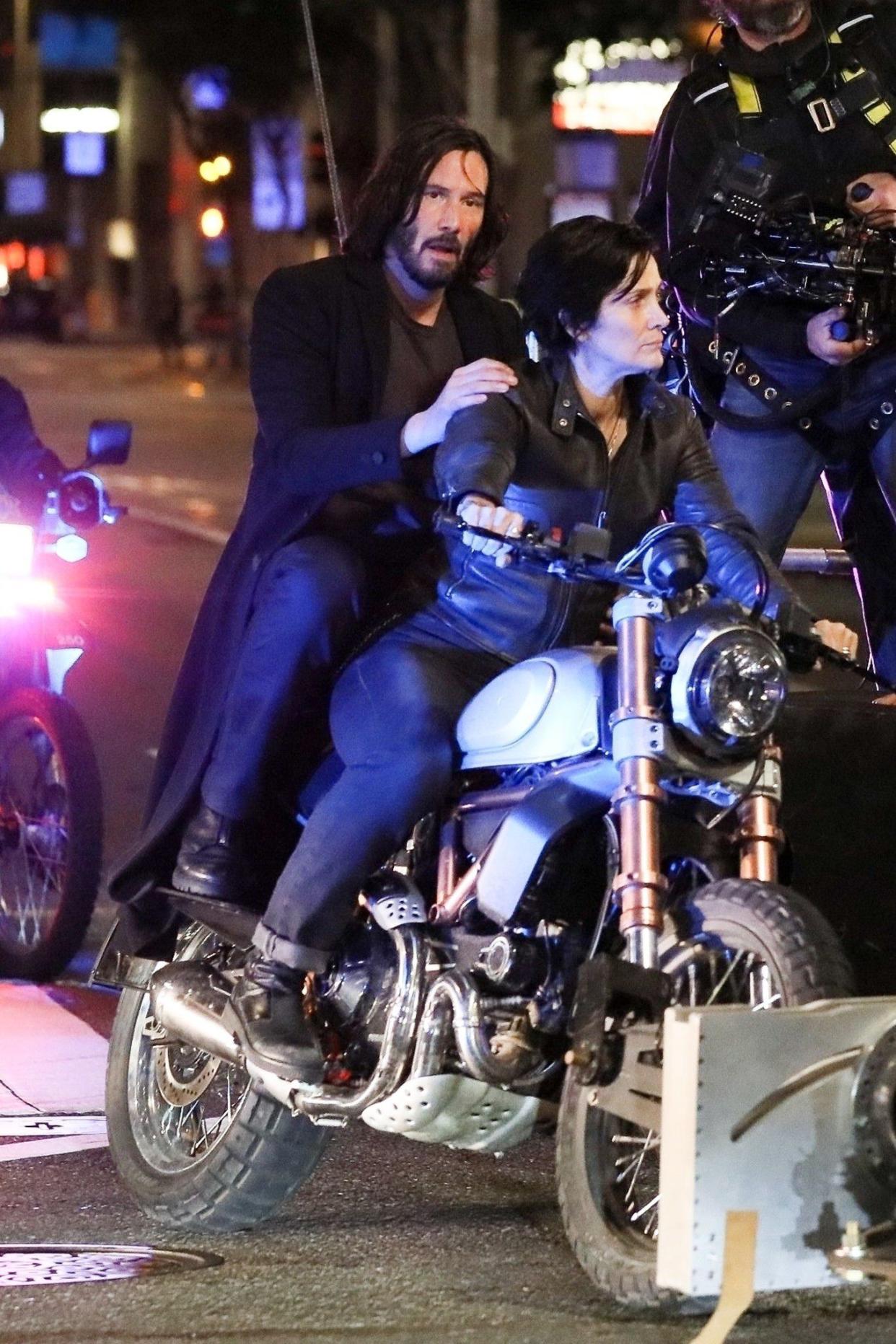 Keanu Reeves, returned as Neo, and Carrie-Anne Moss, reprising her role as Trinity, film an action-packed motorcycle scene for "The Matrix 4," due out on May 21, 2021, in San Francisco.