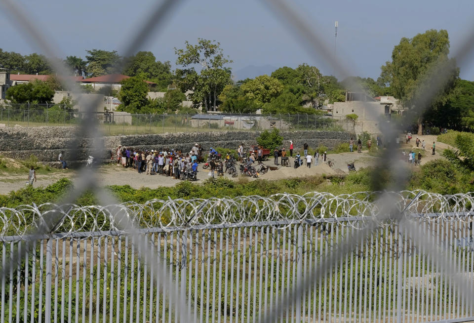 People from Juana Mendez, on the Haitian side of the border, wait in vain to be allowed to cross into Dajabon, Dominican Republic, Wednesday, Oct. 11, 2023. The Dominican Republic partially reopened its border with Haiti on Wednesday to limited commercial activity nearly a month after shuttering the frontier in a continuing spat over the construction of a canal targeting water from a shared river. (AP Photo/Ricardo Hernandez)