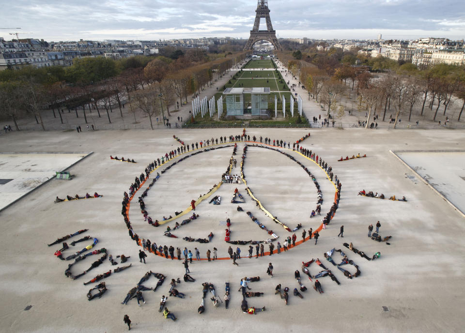 FILE - In this Dec. 6, 2015 file photo, environmentalist activists form a human chain representing the peace sign and the spelling out "100% renewable", on the side line of the COP21, United Nations Climate Change Conference near the Eiffel Tower in Paris. (AP PhotoMichel Euler, File)