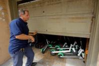 John Heinkel of Scoot Scoop closes a garage door after delivering an impounded scooter to a holding location near the beach in San Diego, California