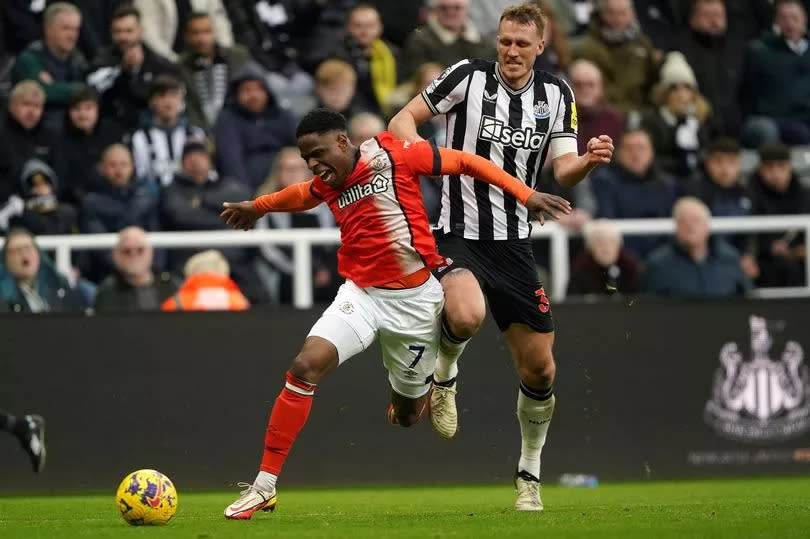Luton Town's Chiedozie Ogbene (left) is held back by Newcastle United's Dan Burn