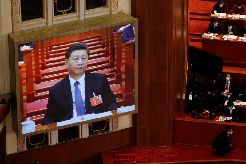Chinese President Xi Jinping is seen on a screen during the opening session of NPC in Beijing