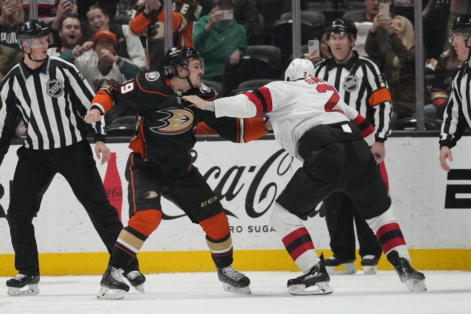 Anaheim Ducks center Sam Carrick, center left, fights New Jersey Devils defenseman Brendan Smith (2) during the second period of an NHL hockey game in Anaheim, Calif., Friday, Jan. 13, 2023. (AP Photo/Ashley Landis)