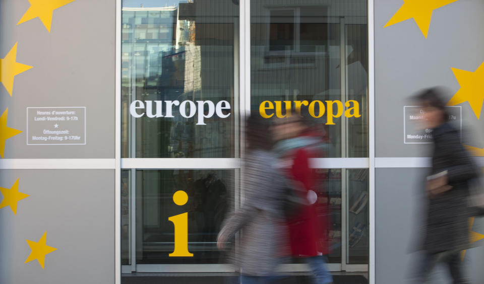 People walk in front of an information office outside of an EU summit in Brussels on Thursday, Nov. 22, 2012. Leaders from around Europe are arriving in Brussels Thursday for what promises to be a turbulent summit on the budget for the 27-country European Union. And for once, Britain will be at the heart of the debate. (AP Photo/Virginia Mayo)