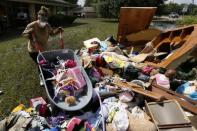 Melissa Gouda removes flood damaged items out of a friend's house in St. Amant, Louisiana. REUTERS/Jonathan Bachman