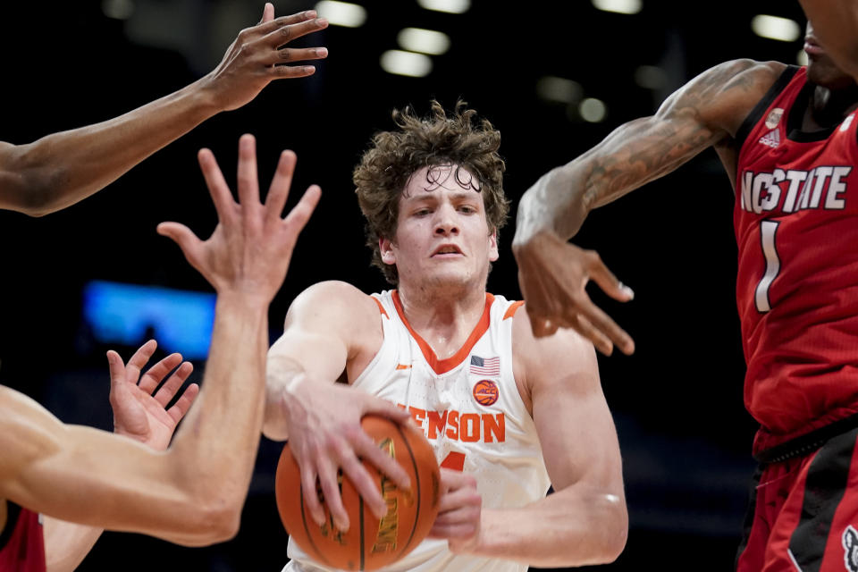 FILE - Clemson's PJ Hall (24) rebounds against North Carolina State's Dereon Seabron (1) during the second half of an NCAA college basketball game of the Atlantic Coast Conference men's tournament, Tuesday, March 8, 2022, in New York. Clemson coach Brad Brownell is on notice to bounce back after a subpar season. He's counting on top scorer in PJ Hall to fully recover from offseason surgeries and make Clemson competitive in the ACC. (AP Photo/John Minchillo, File)