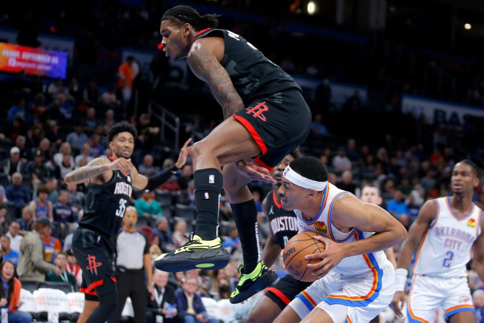 Houston's Kevin Porter Jr. (3) leaps over Oklahoma City's Darius Bazley (7) during an NBA basketball game between the Oklahoma City Thunder and the Houston Rockets at Paycom Center in Oklahoma City, Wednesday, Dec. 1, 2021. 