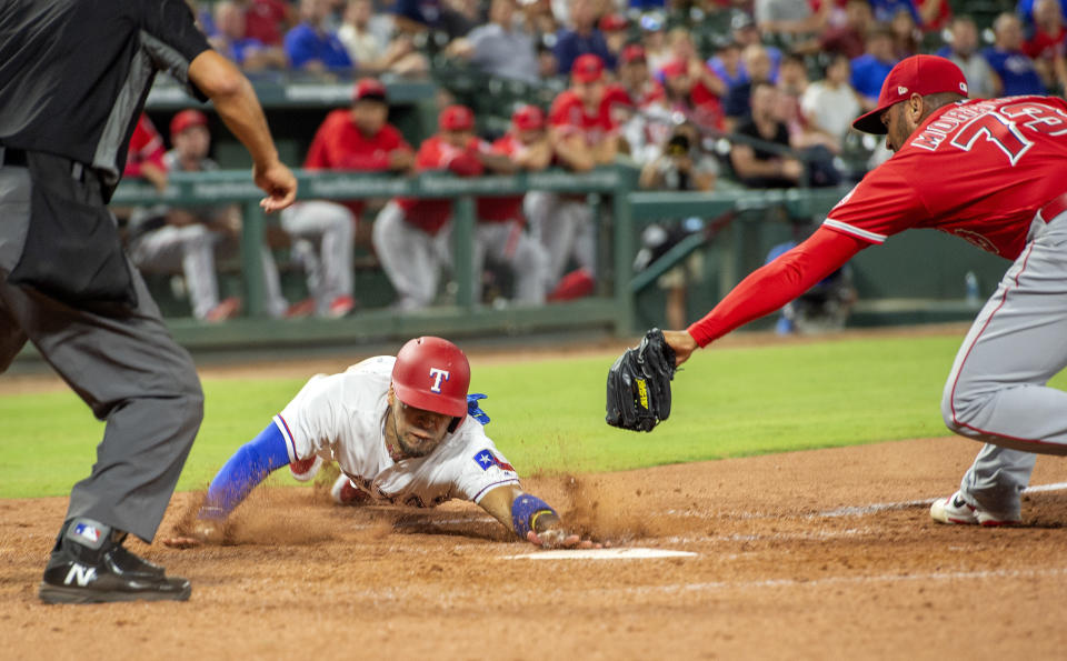 Texas Rangers' Robinson Chirinos scores ahead of the tag of Los Angeles Angels relief pitcher Osmer Morales (73) on a wild pitch by Morales during the eighth inning of a baseball game, Thursday, Aug. 16, 2018, in Arlington, Texas. Texas won 8-6. (AP Photo/Jeffrey McWhorter)